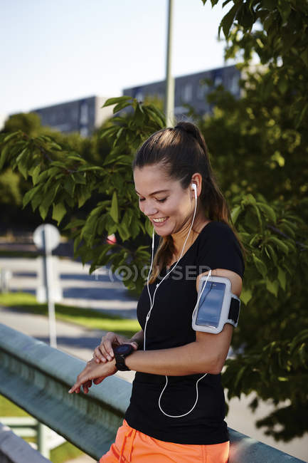 Jovem corredor feminino configuração smartwatch — Fotografia de Stock