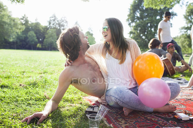 Young couple flirting at park party — Stock Photo