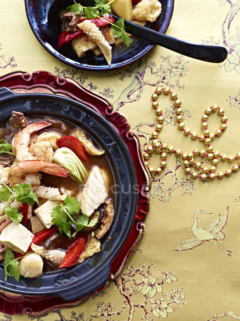 Plato con calamares, gambas, bok choi, tofu y verduras - foto de stock