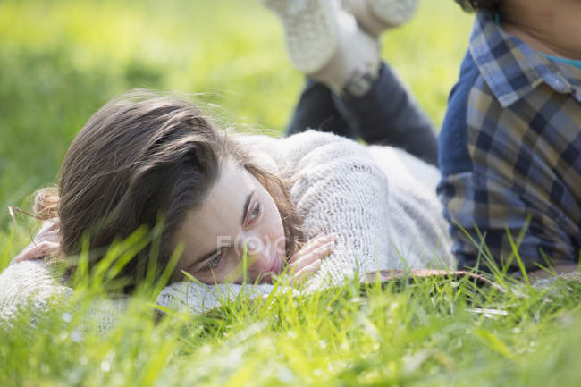 Молода жінка лежить на пікніку ковдру і дивиться геть — стокове фото