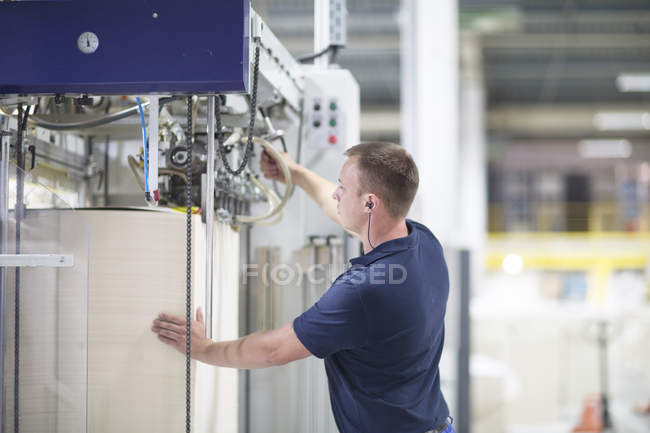 Trabalhador usando a máquina na fábrica de embalagens de papel — Fotografia de Stock