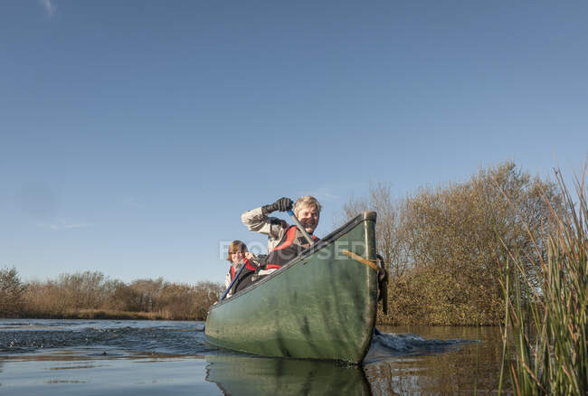 Mulheres adultas meio canoagem no rio — Fotografia de Stock