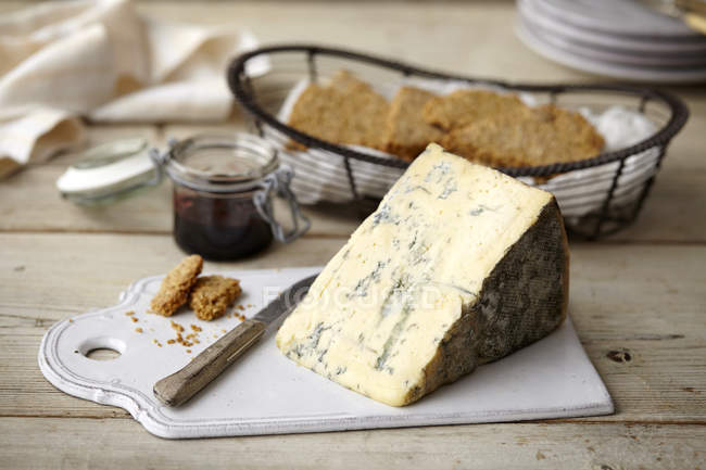 Block of stilton cheese, bread and jam on table — Stock Photo