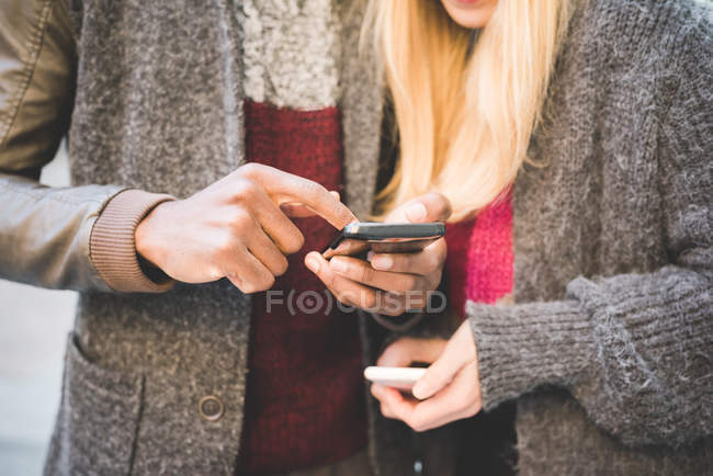 Paar nutzt Smartphone, ausgeschnittenes Bild — Stockfoto