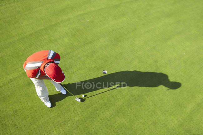 High view of golfer and shadow putting — Stock Photo