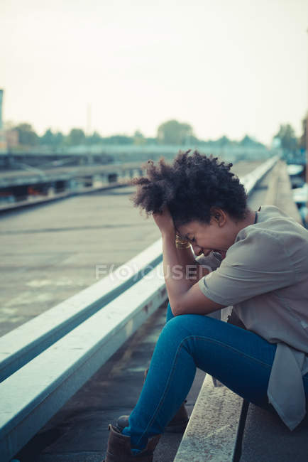 Young woman laughing with head in hands in city — Stock Photo