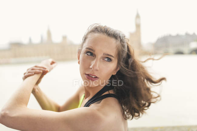 Female runner warming up on Southbank, London, UK — Stock Photo
