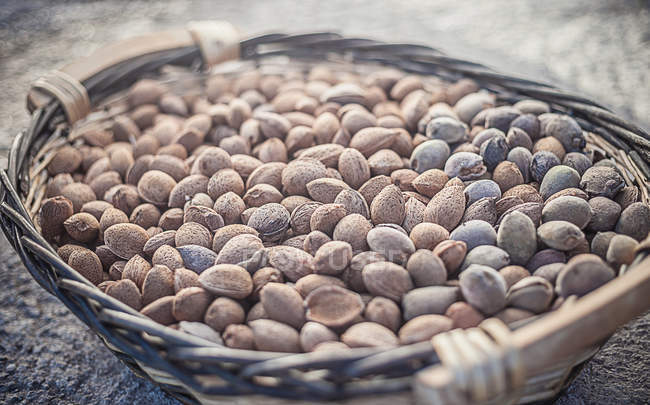 Panier en osier plein de noix d'amande — Photo de stock