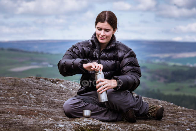 Молода жінка мандрівного відкриття flask на вершині виглядом Скеля, Pateley міст, Nidderdale, Йоркшир землі — стокове фото