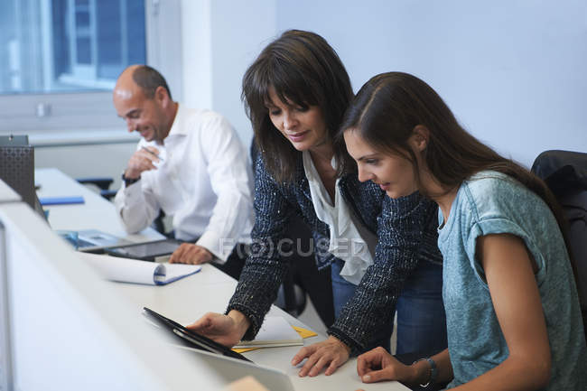Коллеги смотрят на цифровой планшет в офисе — стоковое фото