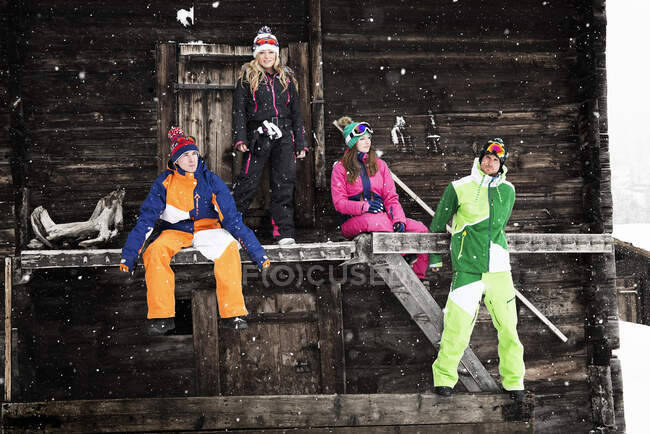 Quattro amici fuori dallo chalet con indosso lo sci — Foto stock
