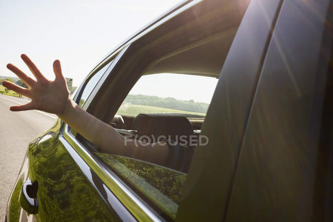Garçons main dehors mouvement fenêtre de voiture — Photo de stock