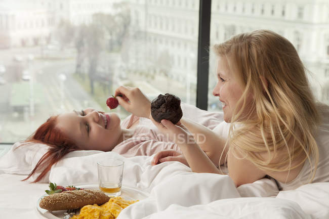 Young women having breakfast in bed, Vienna, Austria — Stock Photo