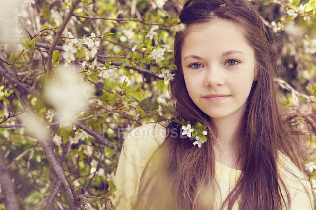 Retrato de niña bonita y flor de árbol - foto de stock