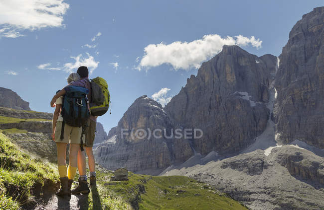 Rear view of hiking couple looking over valley, Brentei Hut, Brenta Dolomite, Italy — Stock Photo