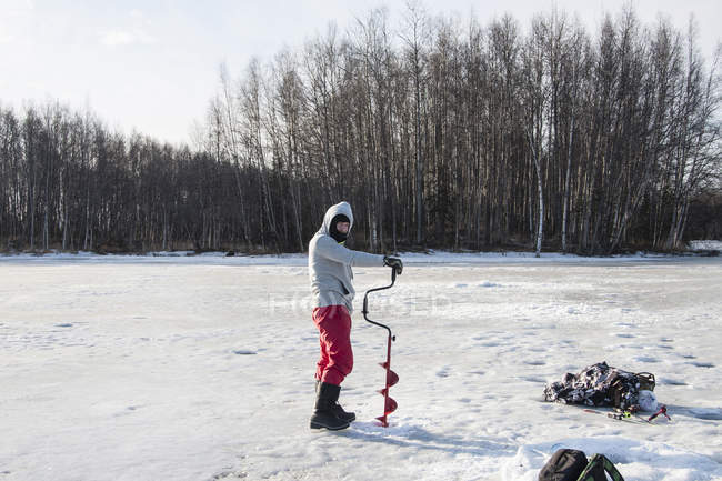 Perforación de hielo de hombre adulto medio, Fairbanks, Alaska - foto de stock