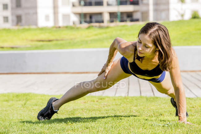 Молода жінка займається спортом у парку. — стокове фото