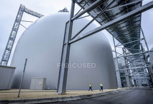 Workers walking through biomass facility, low angle view — Stock Photo