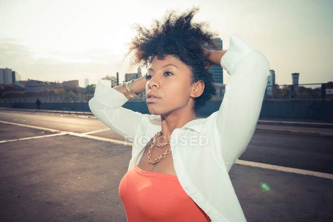 Giovane donna con le mani nei capelli sul parcheggio sul tetto — Foto stock
