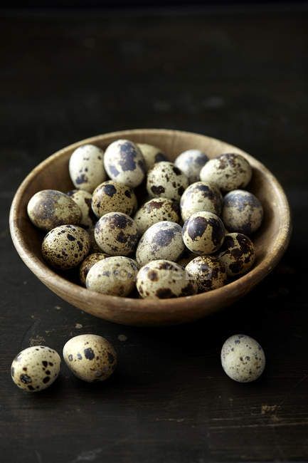 Huevos frescos de codorniz en tazón de madera - foto de stock