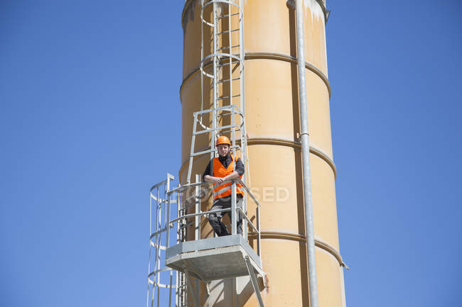 Portrait of worker on smoke stack viewing platform — Stock Photo