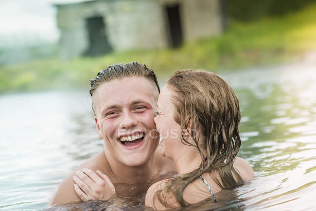 Parejas jóvenes riendo en Secret Lagoon hot spring (Gamla Laugin), Fludir, Islandia - foto de stock