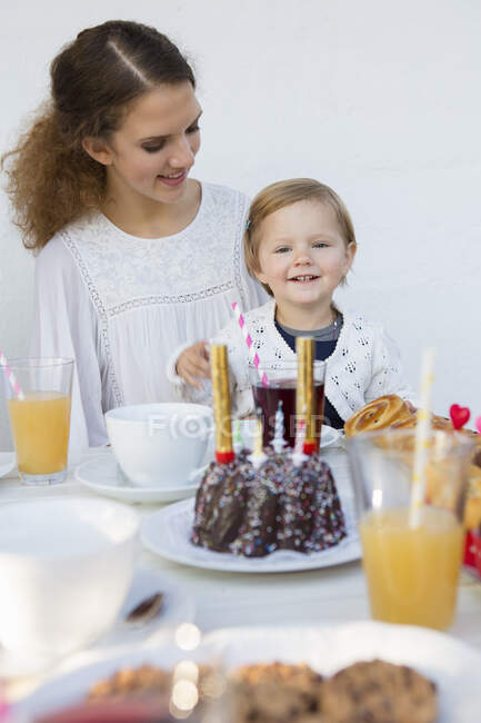 Adolescente e criança na mesa do pátio para a festa de aniversário — Fotografia de Stock