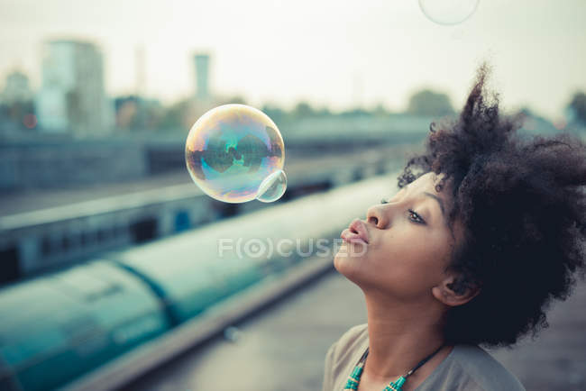 Giovane donna soffia bolle — Foto stock