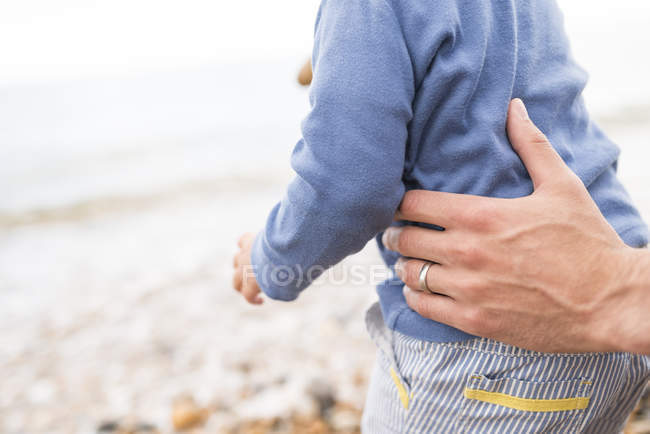 Father holding young son, outdoors, mid section — Stock Photo