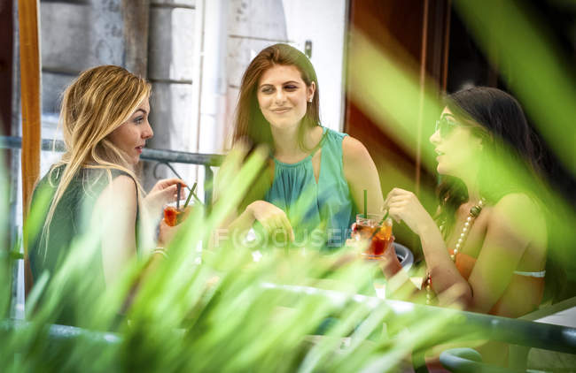 Três jovens amigas tomando coquetéis no café da calçada, Cagliari, Sardenha, Itália — Fotografia de Stock
