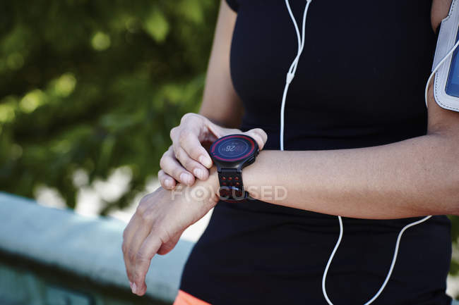 Cortada tiro de jovem feminino corredor configuração smartwatch — Fotografia de Stock