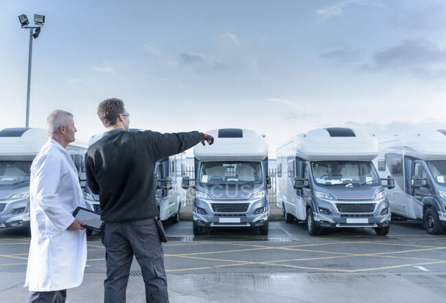 Workers inspecting vehicles on motorhome production line — Stock Photo