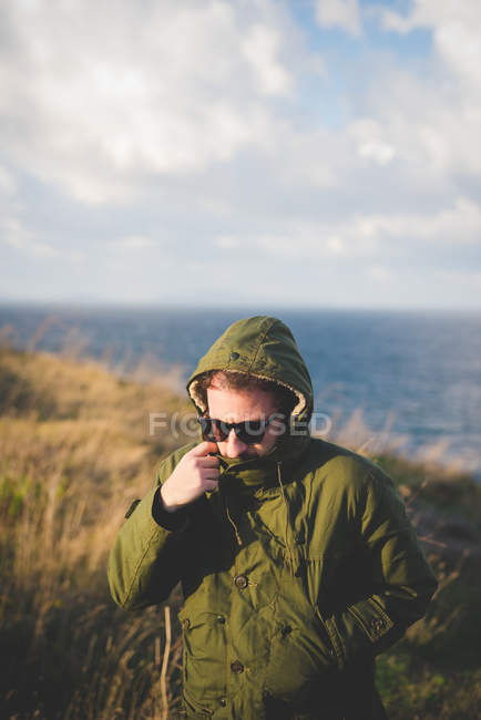 Hombre adulto que pasea por la costa ventosa, Sorso, Sassari, Cerdeña, Italia - foto de stock