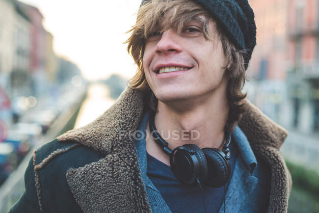 Hombre con auriculares colgados alrededor del cuello - foto de stock