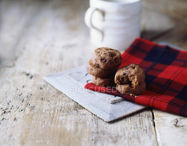 Luxury chocolate chip cookies on tartan tea towel — Stock Photo