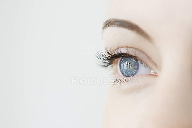 Studio close-up colpo di metà donna adulta guardando occhio blu — Foto stock