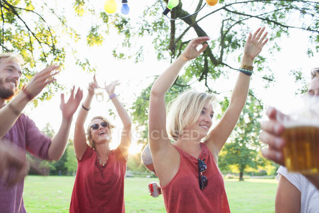 Взрослые друзья танцуют на закате в парке — стоковое фото