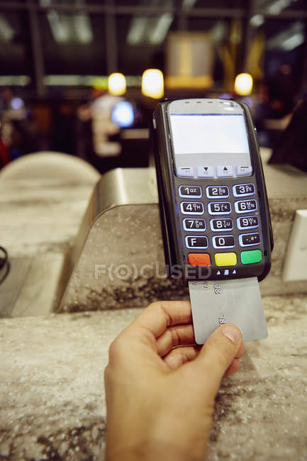 Frauenhand mit Kreditkartenautomat für Restaurant-Bezahlung — Stockfoto