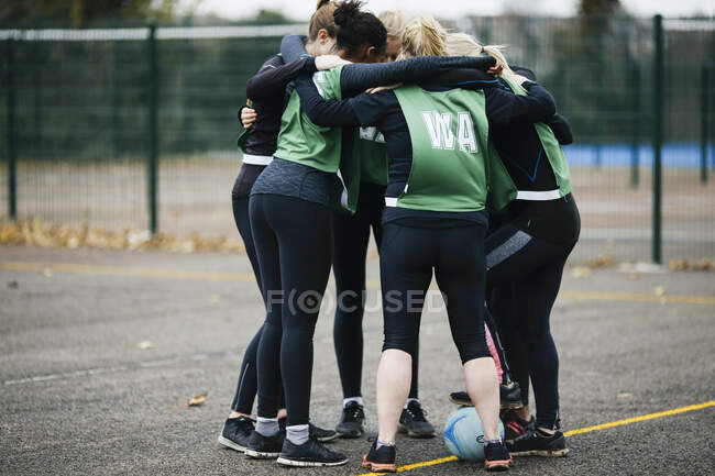 Equipe de netball feminina no planejamento de amontoar no campo de netball — Fotografia de Stock