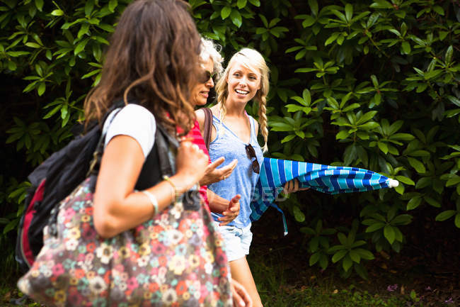 Mature mother and two daughters chatting and walking — Stock Photo