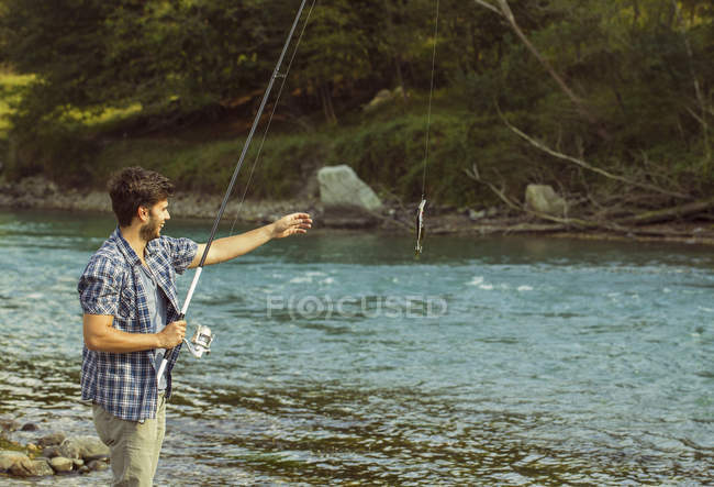 Jovem pescando peixe no rio, Premosello, Verbania, Piemonte, Itália — Fotografia de Stock