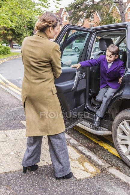 Madre in corsa a scuola, apertura porta auto per figlio — Foto stock