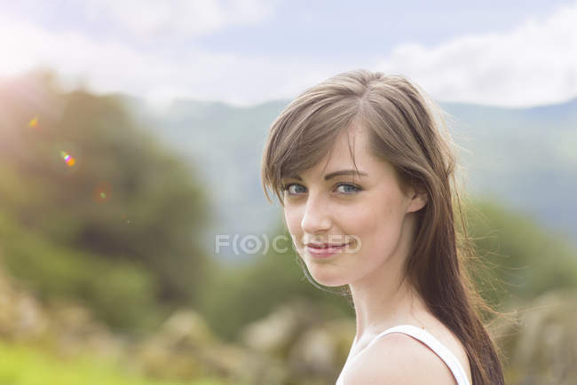 Retrato de mujer joven sonriendo en el campo soleado, de cerca - foto de stock