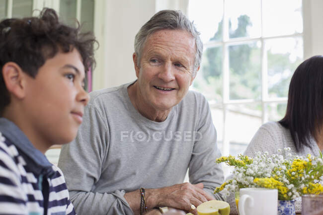 Дідусь і онук сидять за обіднім столом разом — стокове фото