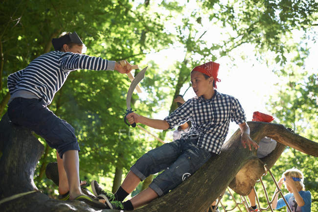 Little boys dressed as pirates playing in trees — Stock Photo
