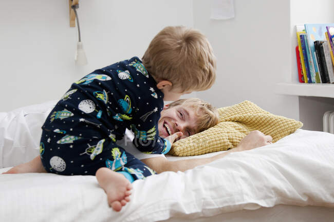Young boy waking up father in bed — Stock Photo