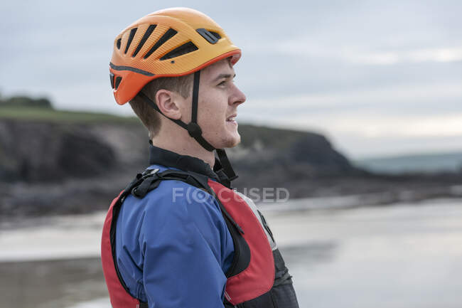 Hombre joven con casco y chaleco salvavidas - foto de stock