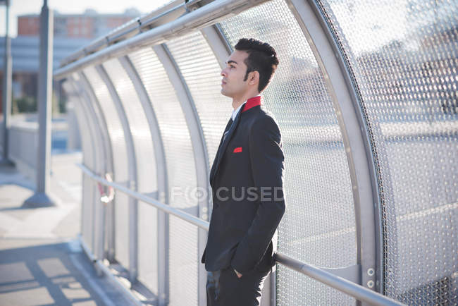 Young businessman by bridge safety fence — Stock Photo