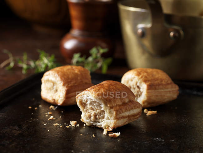 Mini sausage rolls and thyme leaves on background — Stock Photo