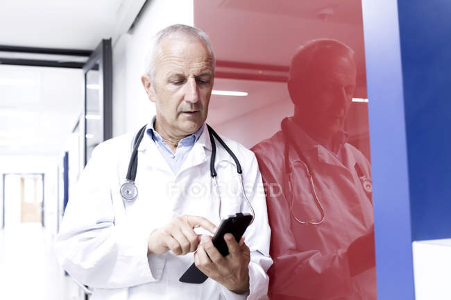 Médecin masculin utilisant un smartphone à l'hôpital — Photo de stock